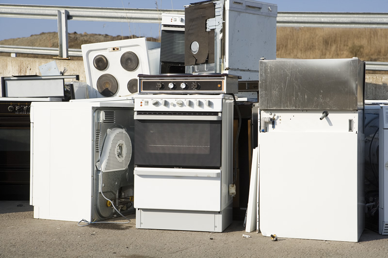 Pile of old stoves, ovens, and household appliances ready for pickup by appliance removal services kent wa